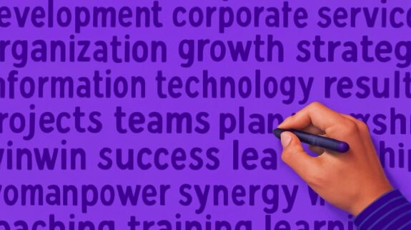 Xây Dựng Chiến Lược Marketing Hiệu Quả Bàn tay cầm bút viết lên các thuật ngữ kinh doanh, minh họa cho việc lập một chiến lược marketing online hiệu quả.