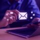 Người dùng tương tác với các biểu tượng email trên giao diện kỹ thuật số, minh họa cho dịch vụ marketing automation chuyên nghiệp.