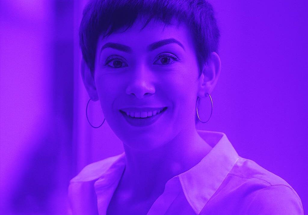 Chân dung một nữ nhân viên văn phòng chuyên nghiệp với mái tóc pixie, mỉm cười tự tin.