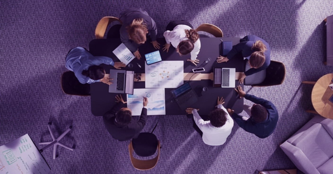 Nhìn từ trên xuống một nhóm đang họp bàn, cùng nhau lập chiến lược marketing online trên bàn làm việc với laptop và tài liệu.